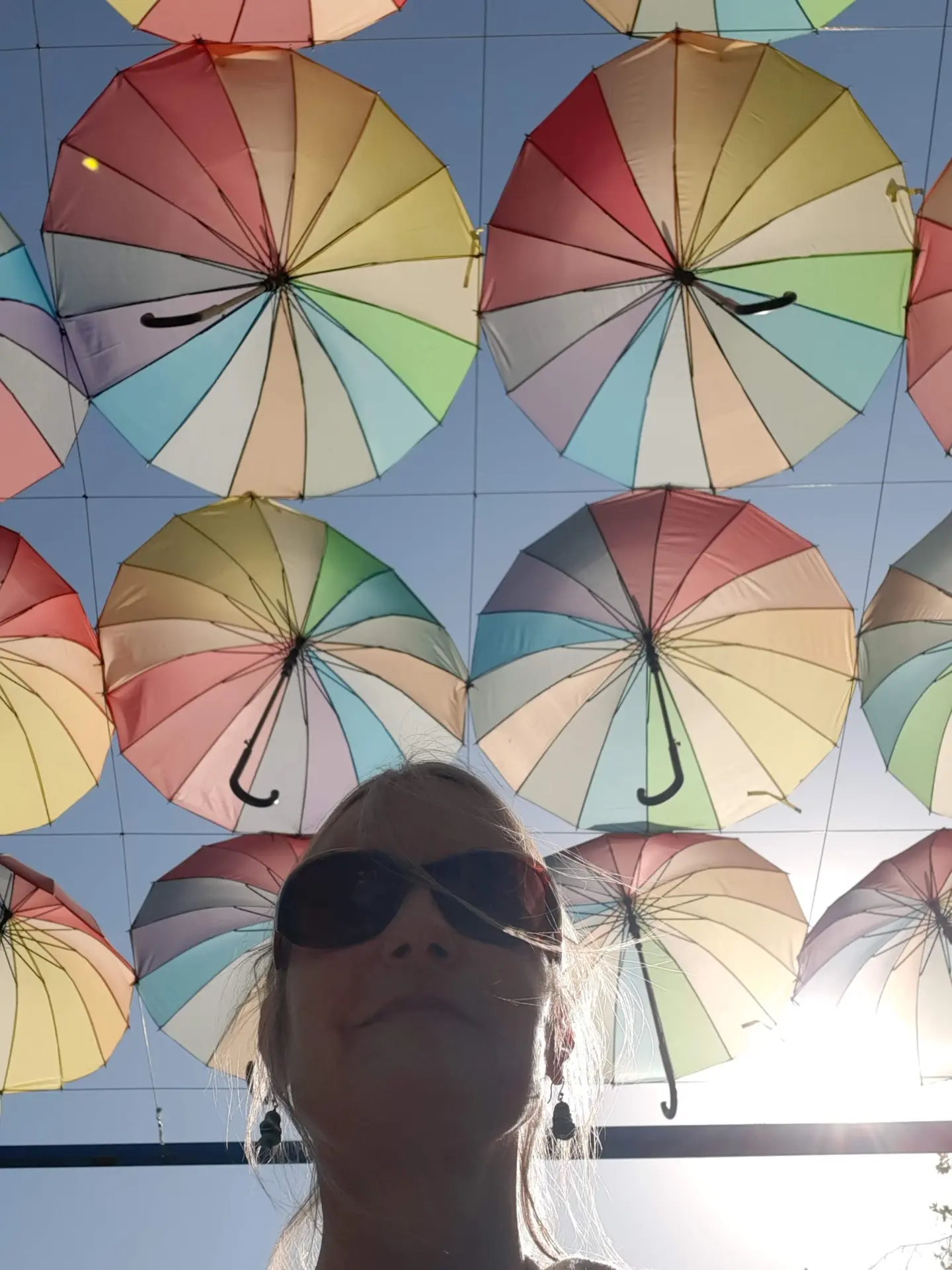 Nicky beneath a colourful canopy of umbrellas