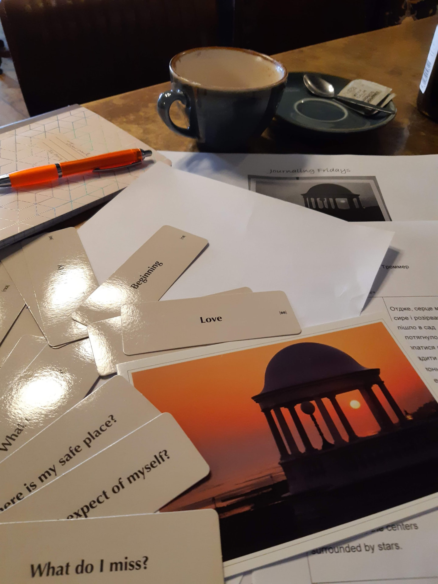 Photographs, prompt cards, notebook and pen on a table