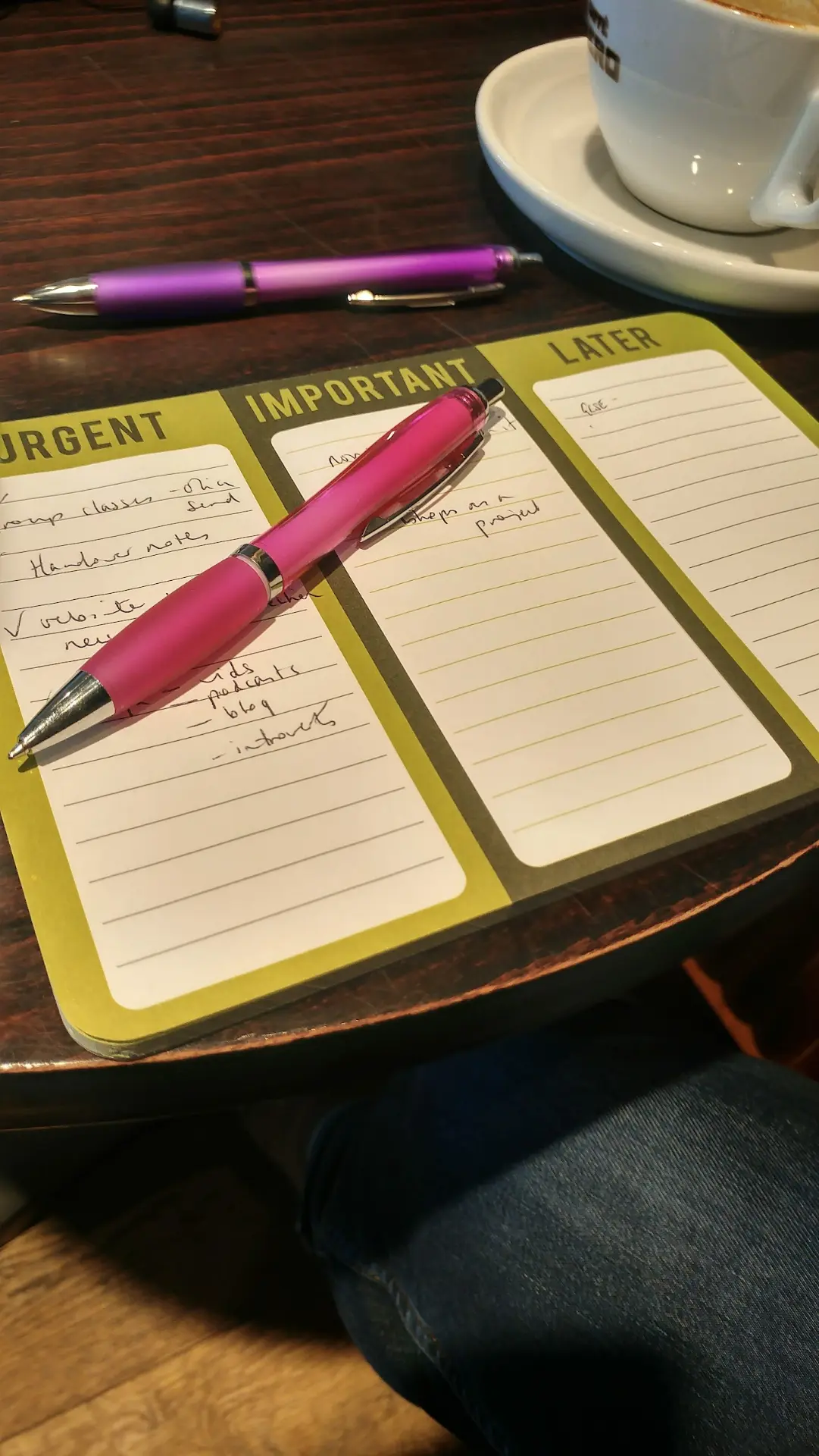 Handwritten priorities beside colourful pens and a coffee